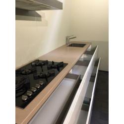 Mooie witte hoogglans keuken met losse kastenwand.