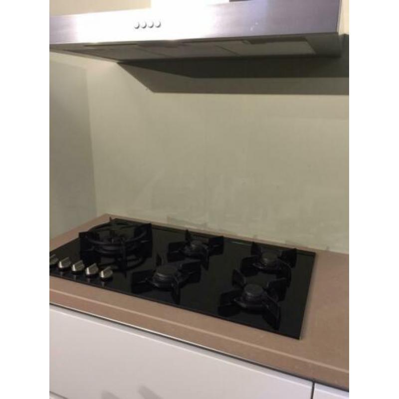 Mooie witte hoogglans keuken met losse kastenwand.
