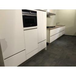 Mooie witte hoogglans keuken met losse kastenwand.