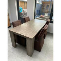 Eetkamertafel met 4 verrijdbare stoelen.